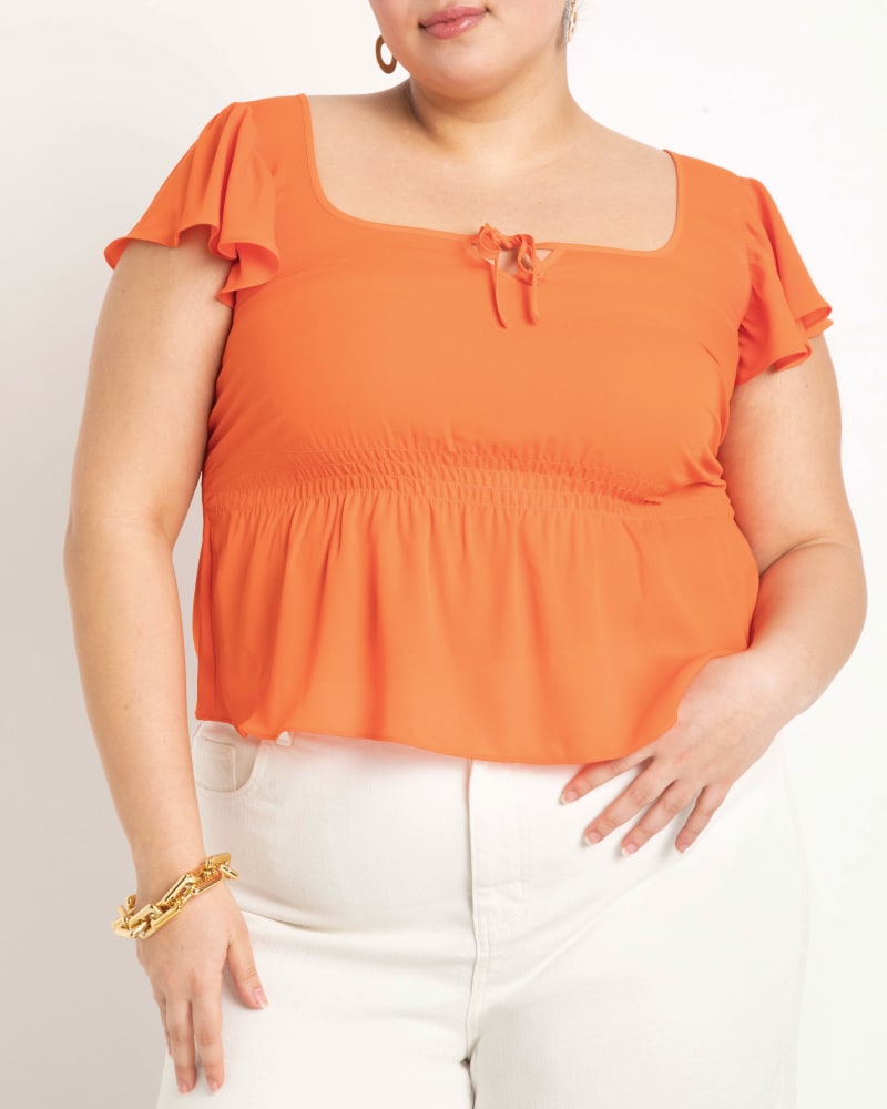 Front of a model wearing a size 14 Flutter Sleeve Peplum Blouse in Bright Orange by ELOQUII. | dia_product_style_image_id:204080